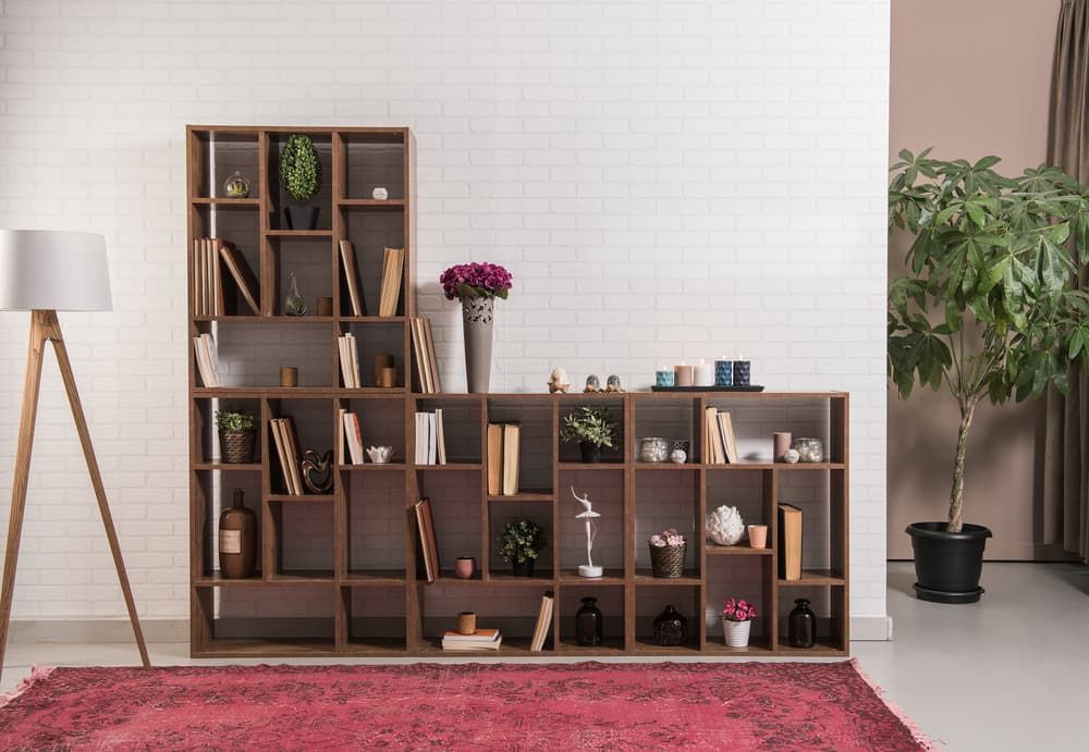 Wooden Bookshelf With Decor Against a White Brick Wall — Hastings Specialty Furniture In Port Macquarie, NSW