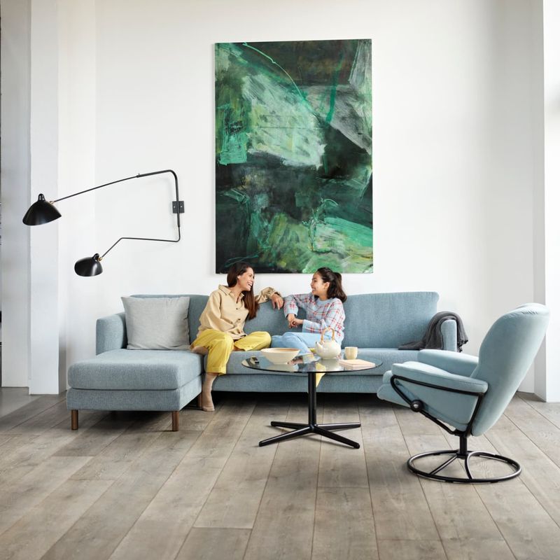 Two People Seated on a Blue Sofa — Hastings Specialty Furniture In Port Macquarie, NSW