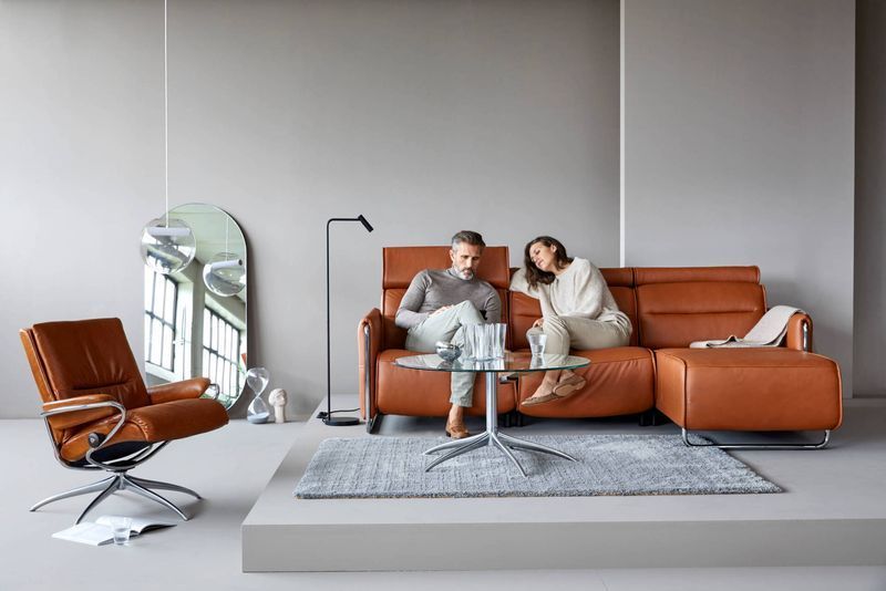 Couple on a Brown Leather Sectional Sofa — Hastings Specialty Furniture In Port Macquarie, NSW