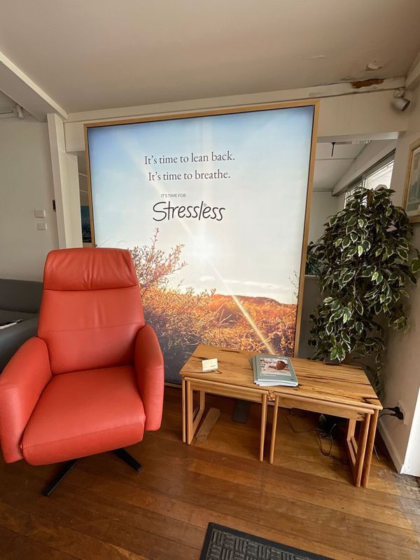 Red Recliner Next to a Wooden Table and a Plant — Hastings Specialty Furniture In Port Macquarie, NSW