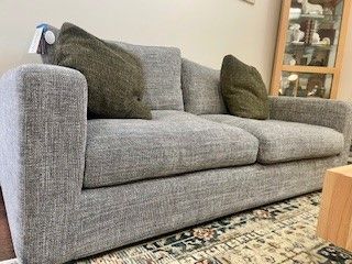 Grey Upholstered Sofa With Two Green Pillows — Hastings Specialty Furniture In Port Macquarie, NSW