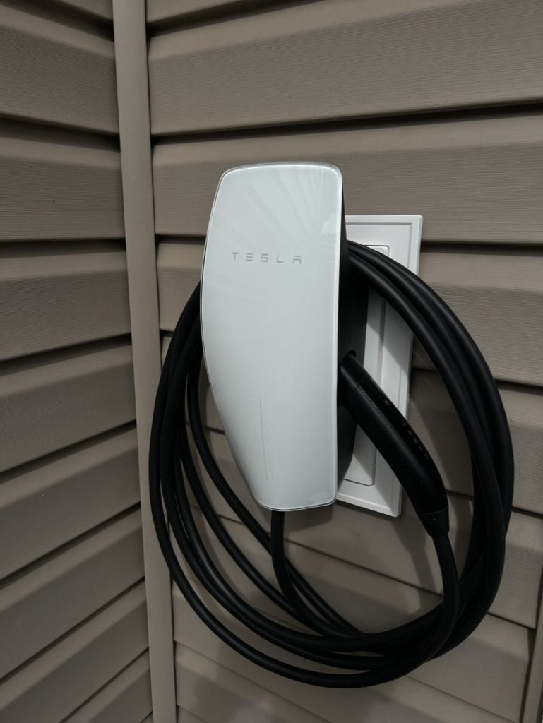 A tesla charging station with a cable attached to it