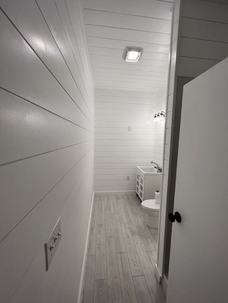 A bathroom with white walls , a toilet , and a sink.