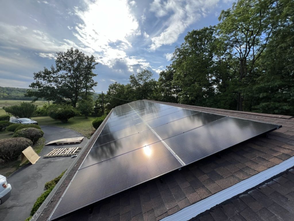 A row of solar panels are sitting on top of a roof.
