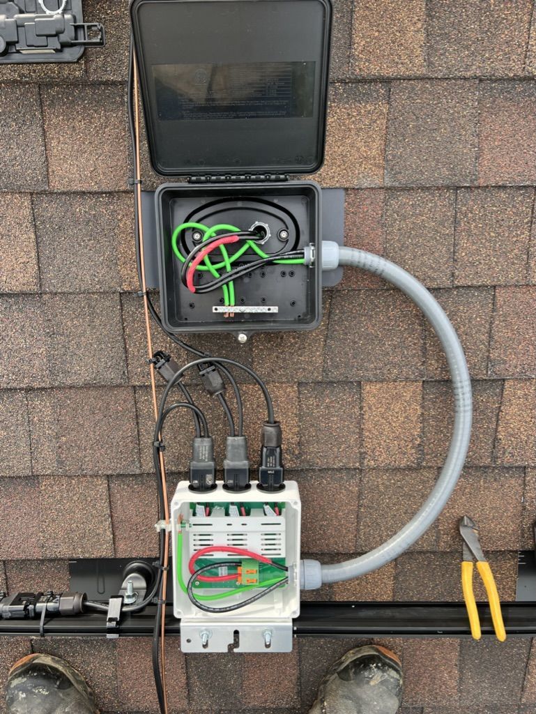A box with wires coming out of it is attached to a roof.
