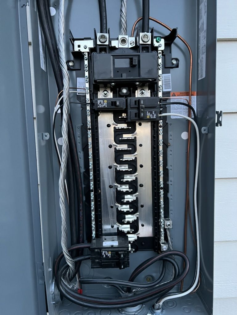 A close up of an electrical panel on the side of a house.