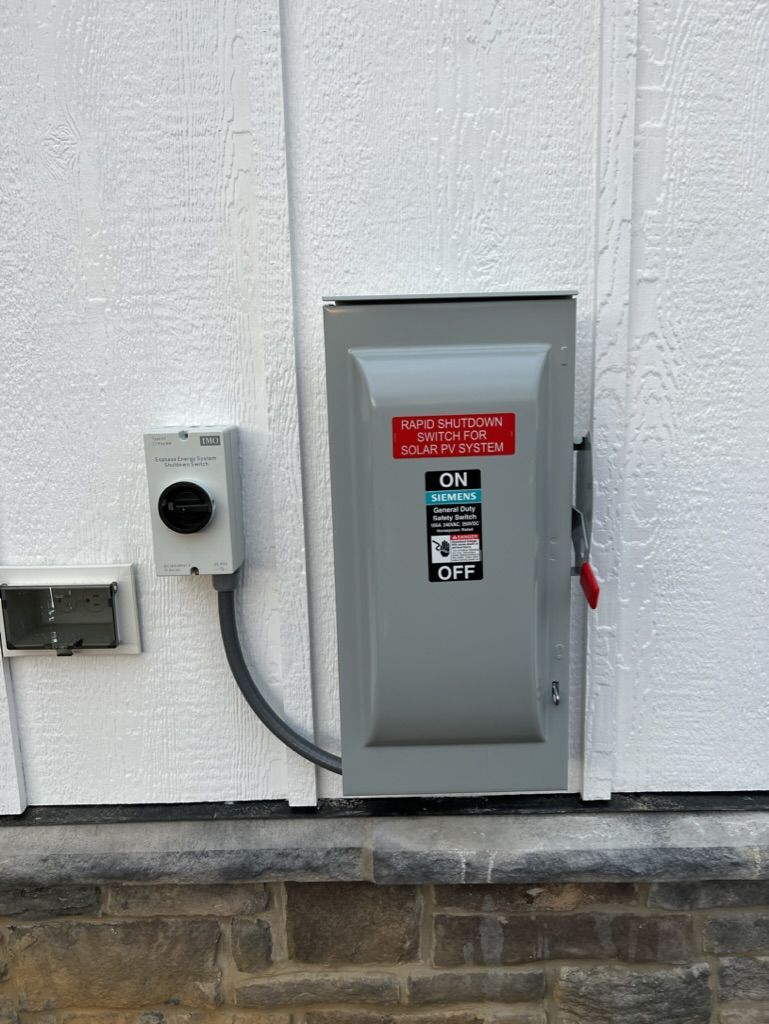 A electrical box is attached to the side of a building.