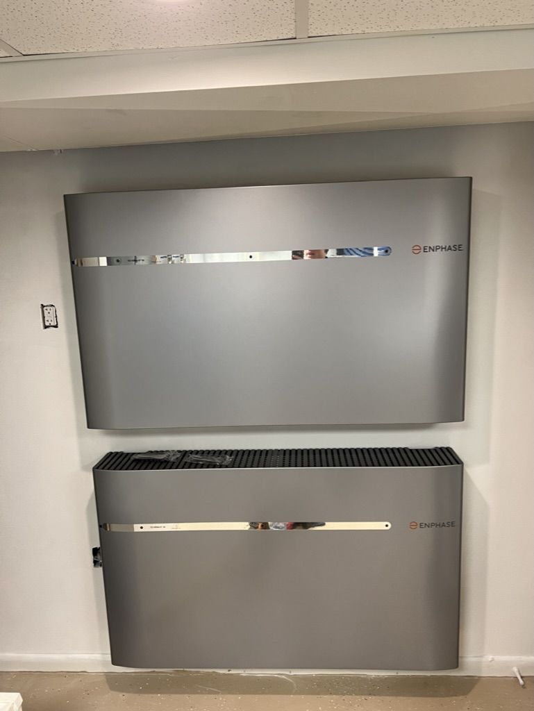 A large gray refrigerator is hanging on a white wall.