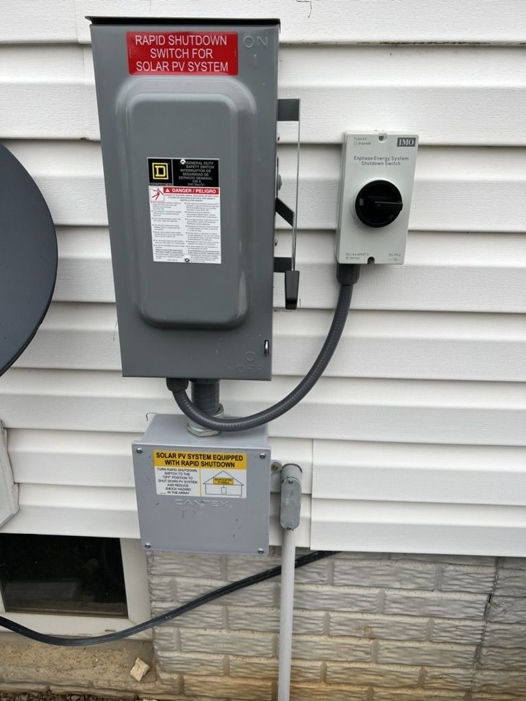 A electrical box is attached to the side of a house.