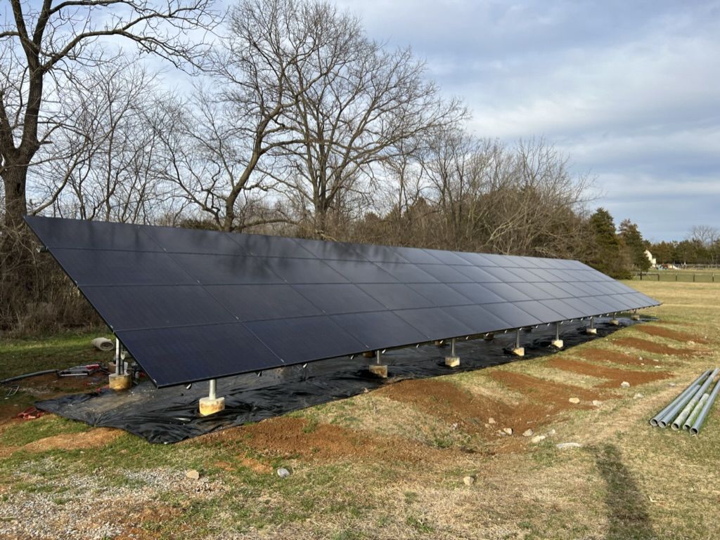 A row of solar panels sitting on top of a dirt field.