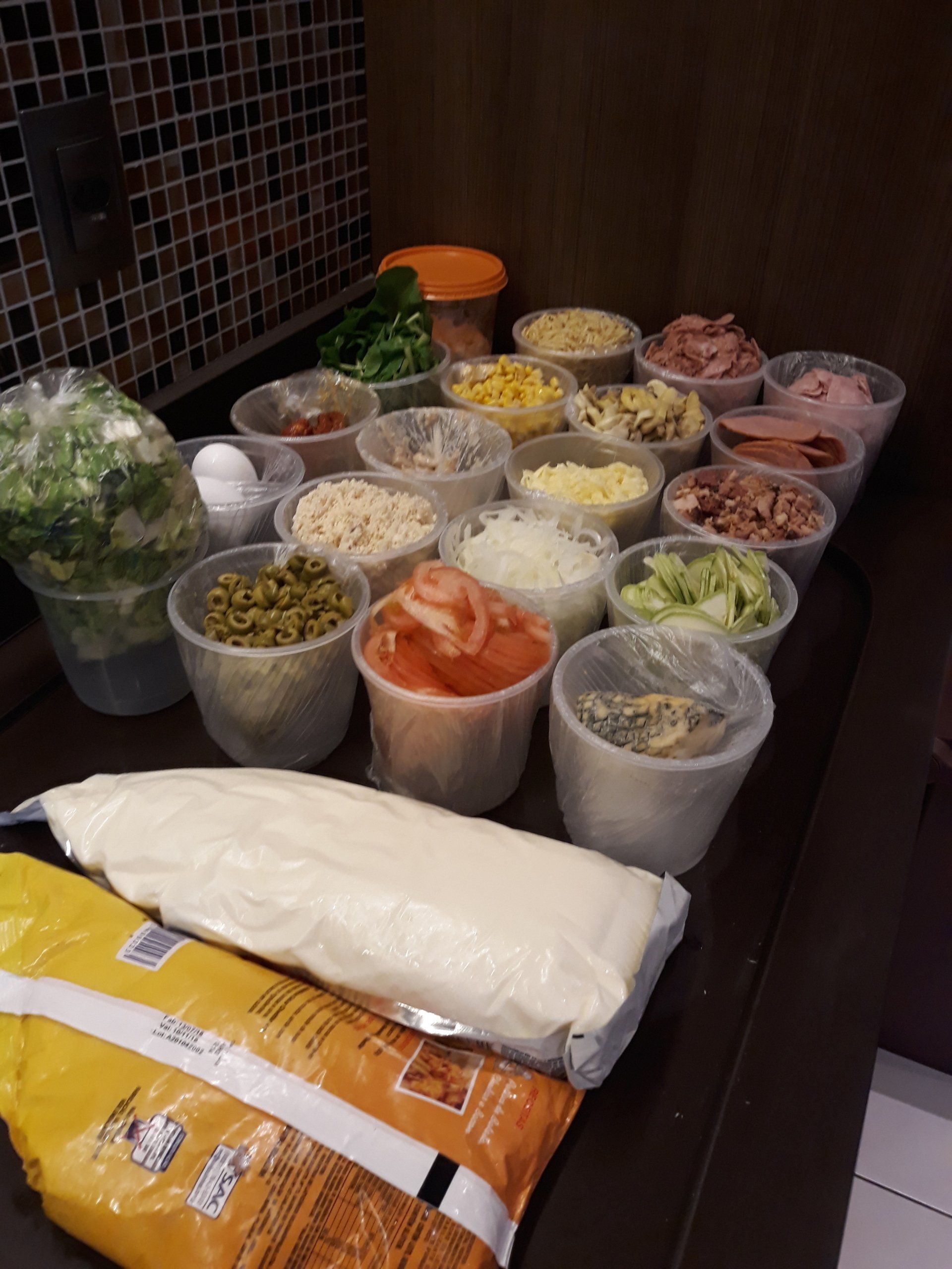 Um monte de recipientes de comida, incluindo um saco de maionese