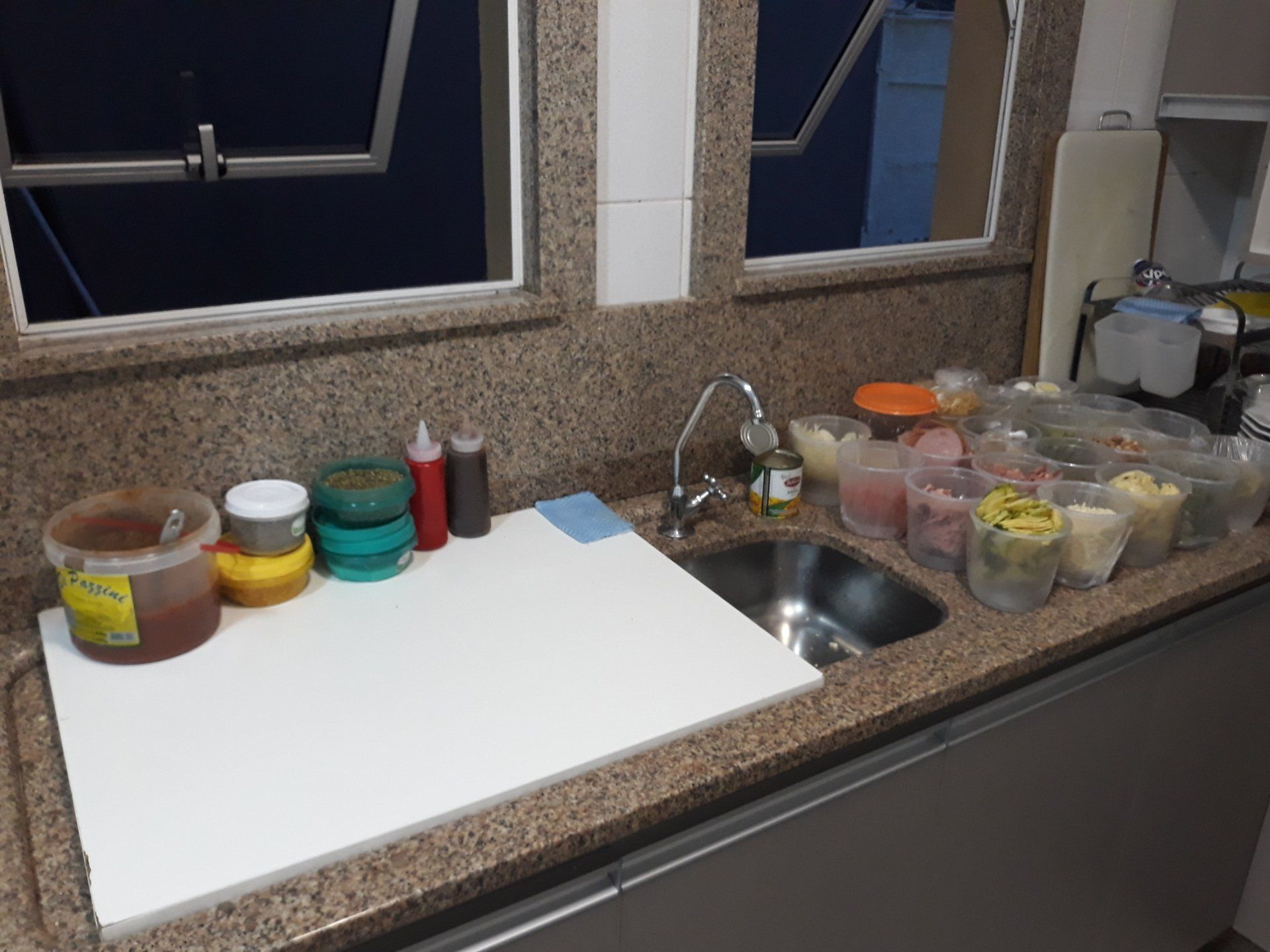 Um balcão de cozinha com uma pia e uma tábua de corte