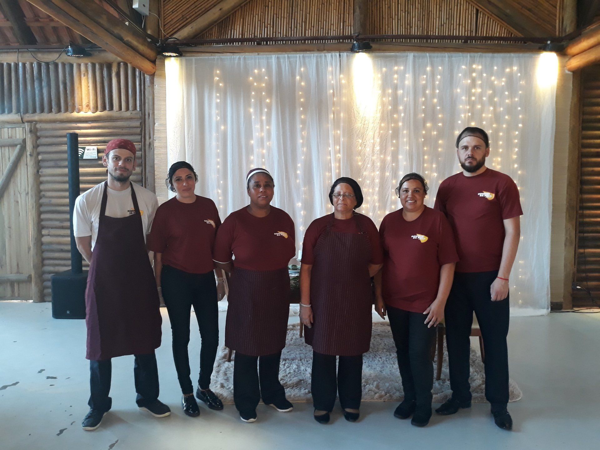 Um grupo de pessoas em pé, uma ao lado da outra, em uma sala.