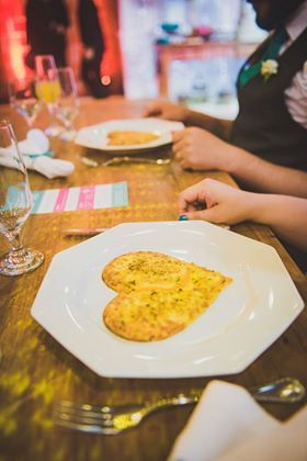 Um prato de comida com um biscoito em forma de coração sobre uma mesa.