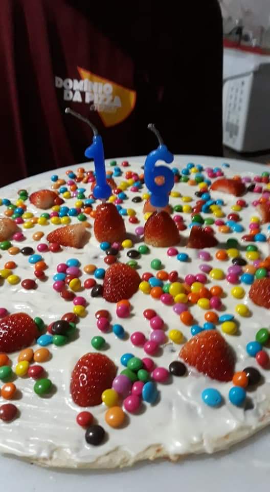 Um bolo de aniversário com velas e granulados