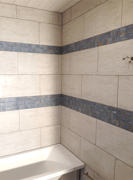 Une pièce avec un sol carrelé et un mur en pierre