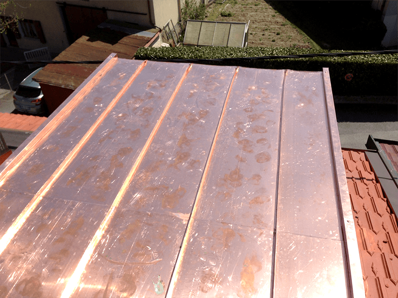 Un toit en cuivre avec un toit rouge en arrière-plan