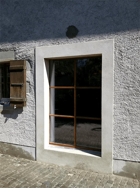 Un bâtiment avec une fenêtre et une boîte aux lettres sur le côté