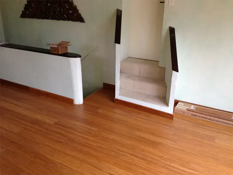 Une pièce avec un parquet et des escaliers en bois.