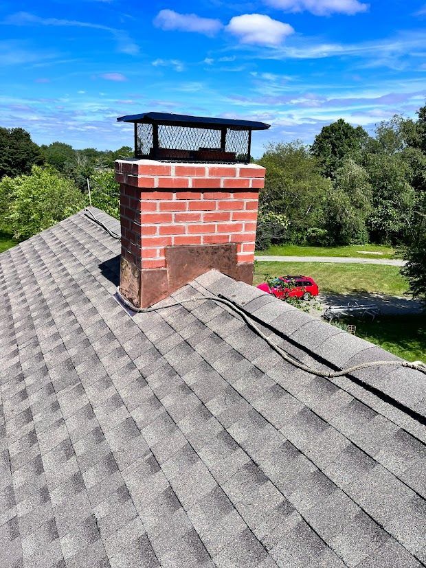 A brick chimney is sitting on top of a roof.