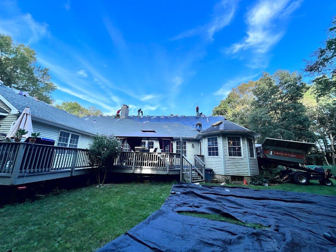 A house with a roof that is being installed on a sunny day.