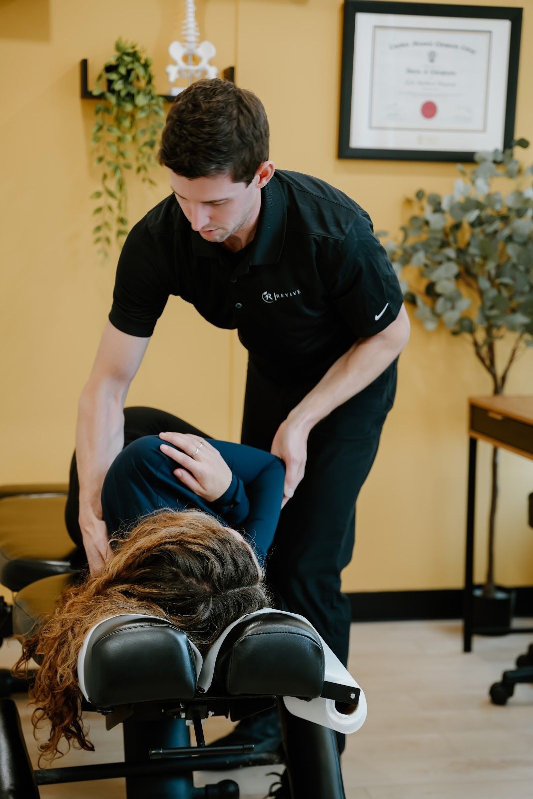 Chiropractor adjusting a patient's back in a clinic setting.