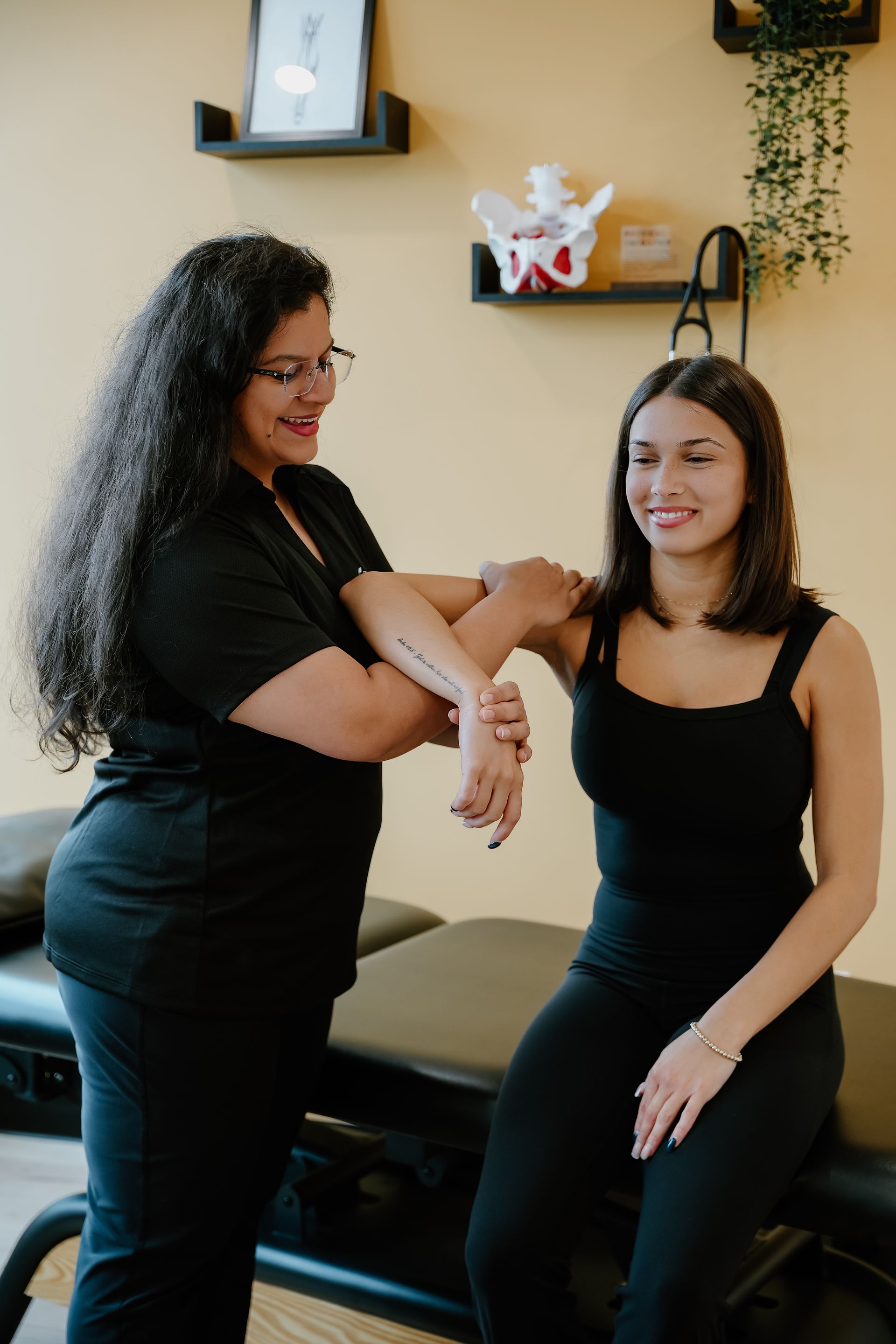 A healthcare professional examining a person's arm in a doctor's office.