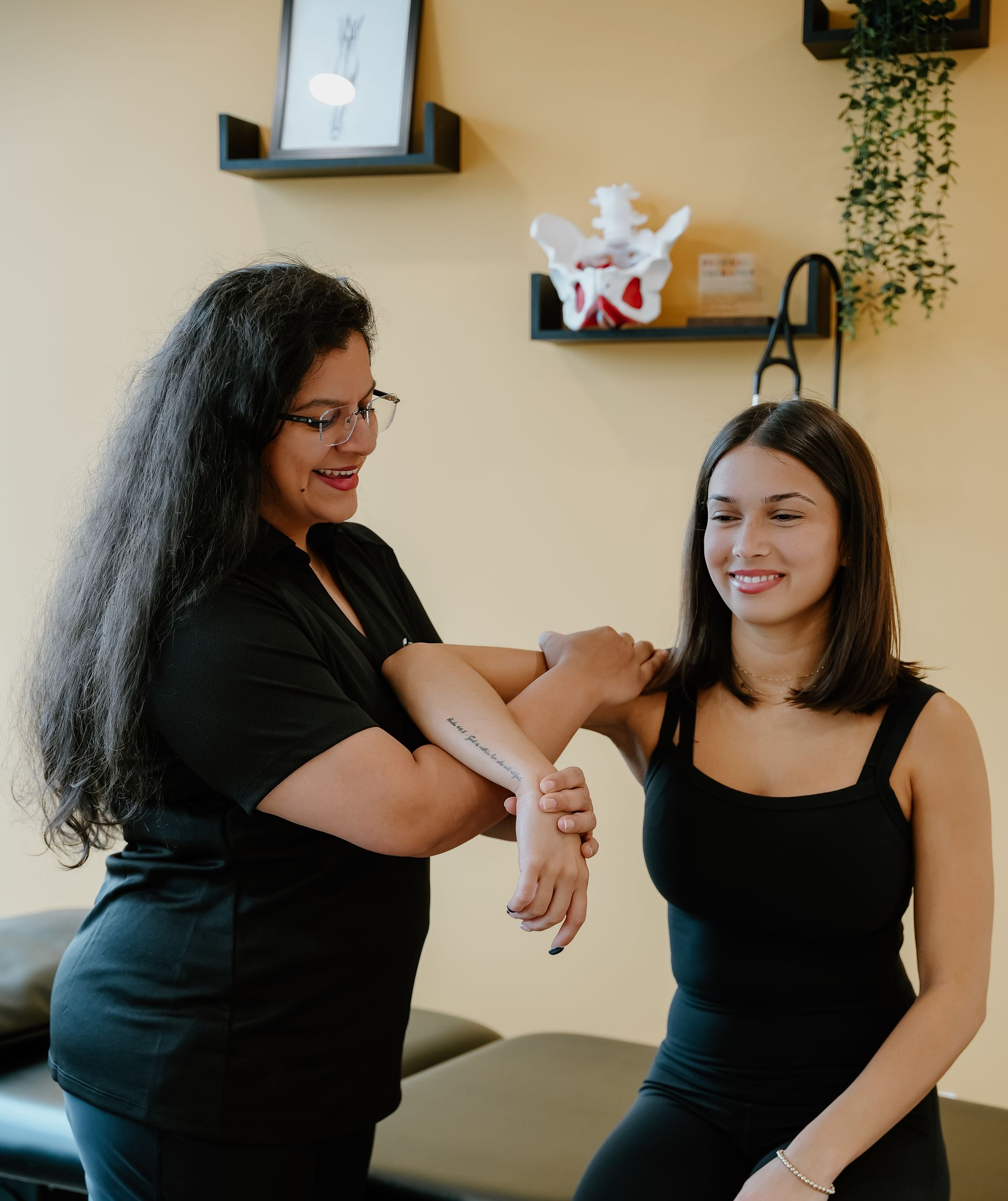A healthcare professional examining a person's arm in a doctor's office.