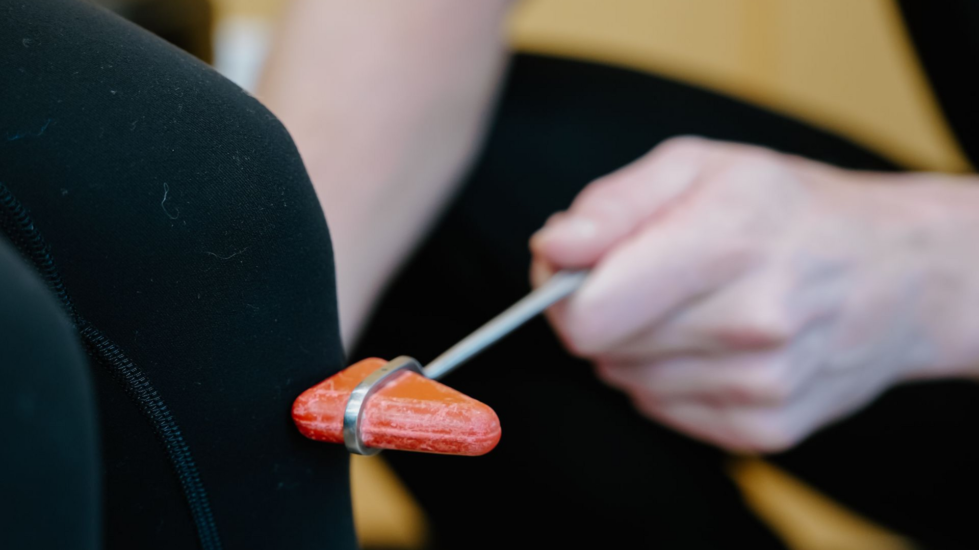 A reflex hammer tapping a patient’s knee during a physical exam.