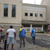 A group of men are standing in front of a building.