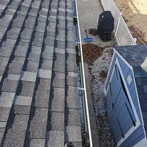 An aerial view of a gutter on a roof next to a shed.