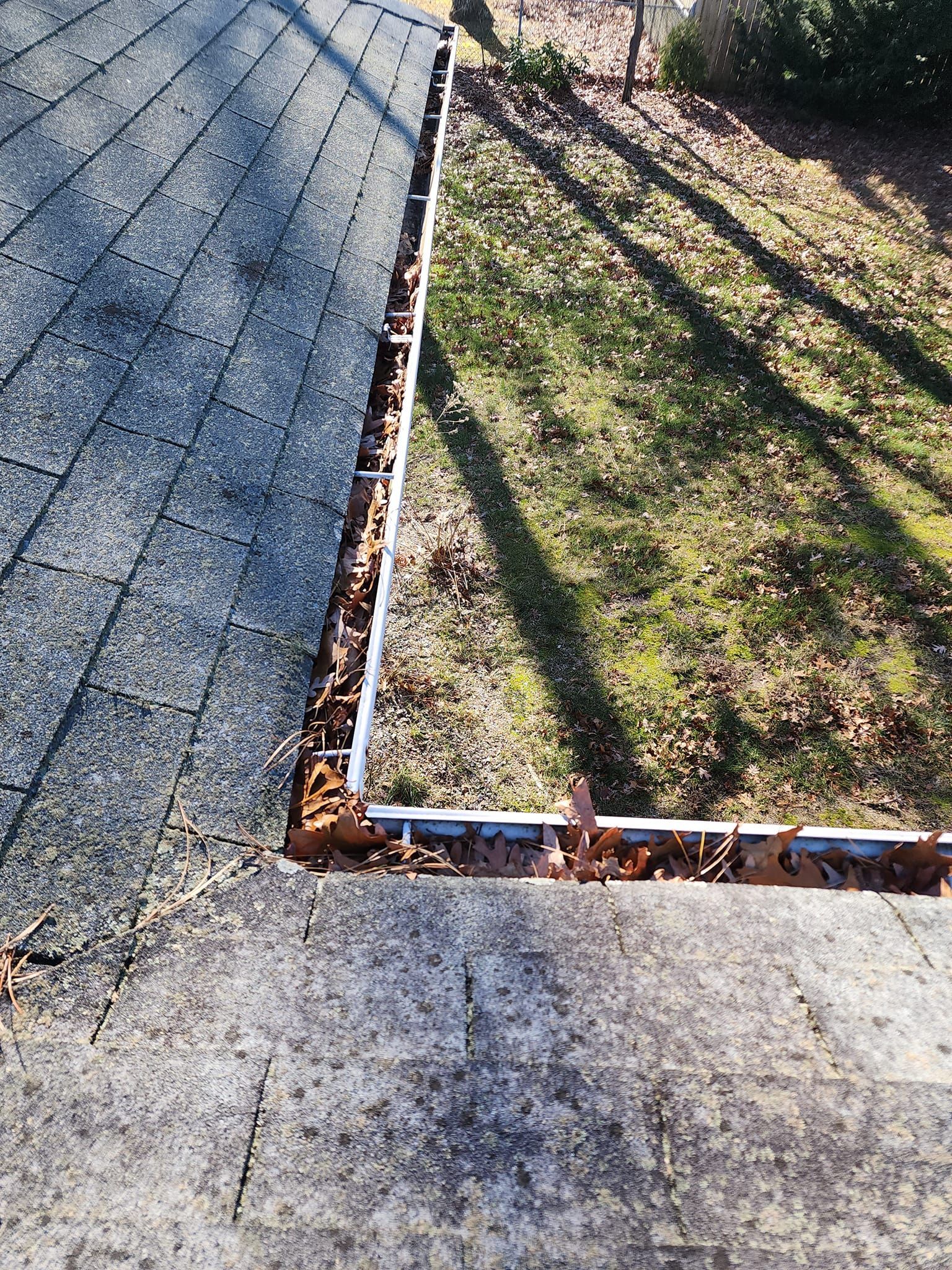A roof with a lot of leaves before cleaning.