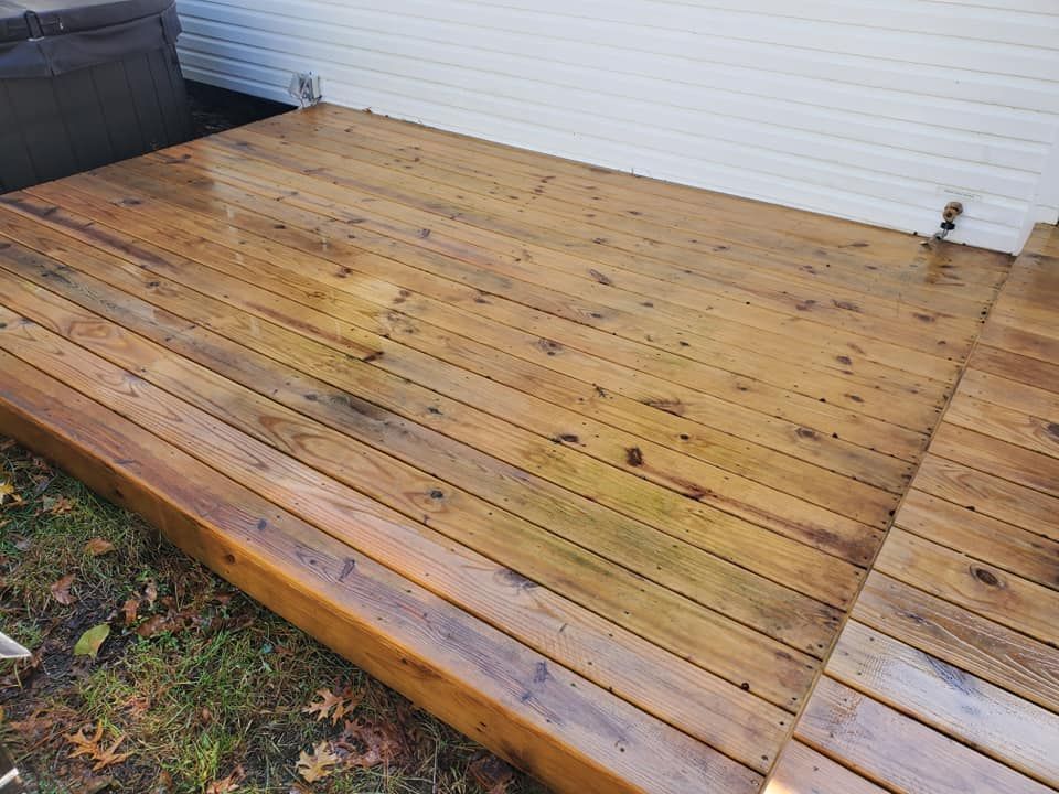 A wooden deck with a white house in the background.