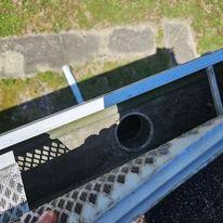 A person is standing on a staircase next to a pipe.