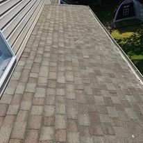 A roof with a brick walkway leading to it and a tent in the background.