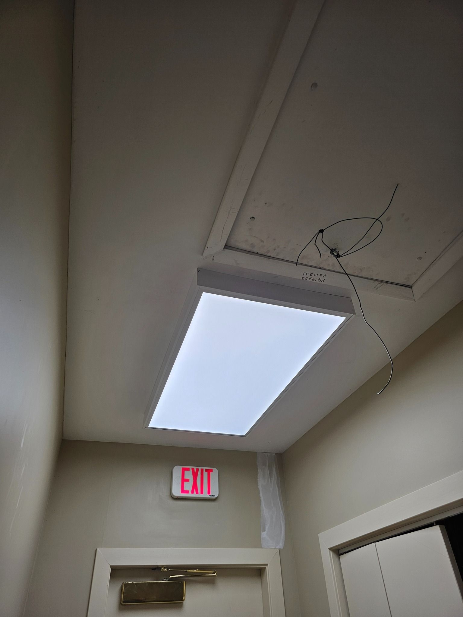 Woman in straw hat smiles, holding wine glass near a lake.