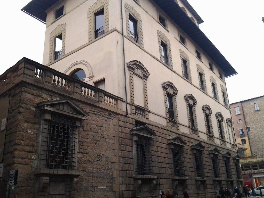 Edificio con facciata in pietra a Firenze, Italia, con numerose finestre e balconi.