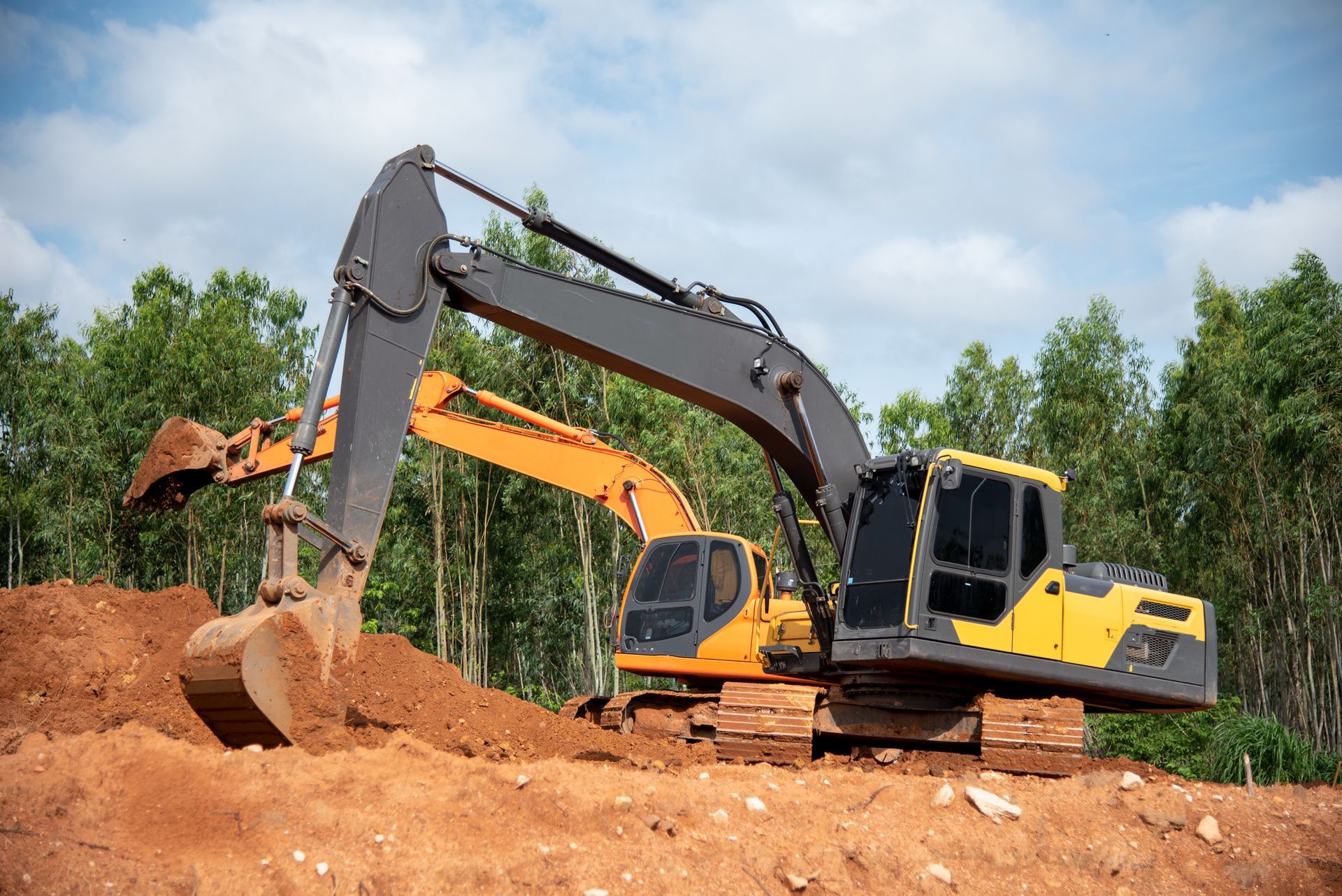 Two yellow excavators at a construction site, operated by excavation equipment contractors.