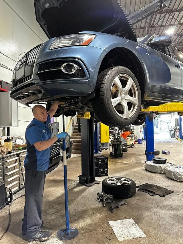 Expert Staff at work with Car Lifted Up, Repairing below the car | Bruno Automotive