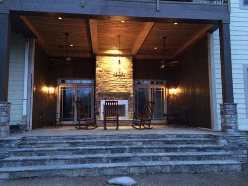 A porch with rocking chairs and a fireplace