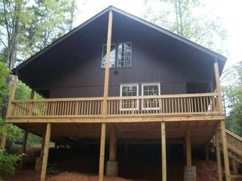 A large brown house with a large wooden deck