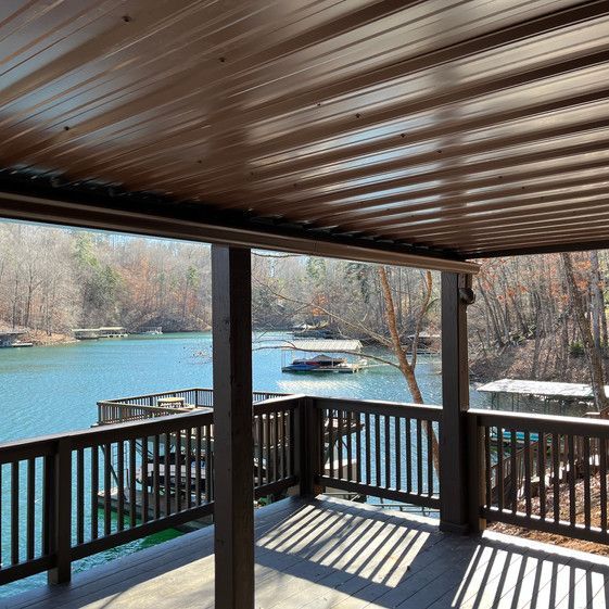 A deck with a view of a lake and trees