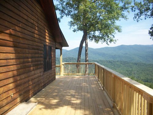 A wooden deck with a view of mountains and trees