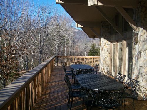 A large wooden deck with a table and chairs on it