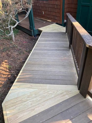 A wooden deck with stairs leading up to a house.
