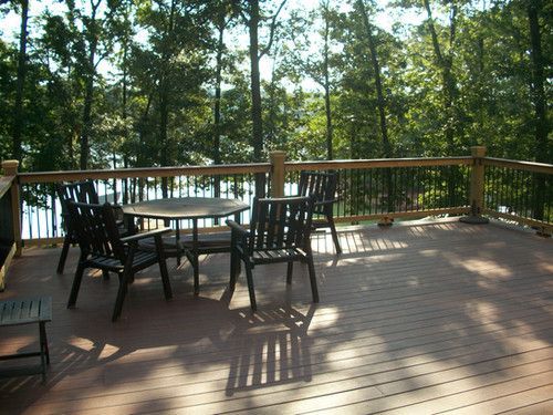 A deck with a table and chairs overlooking a lake