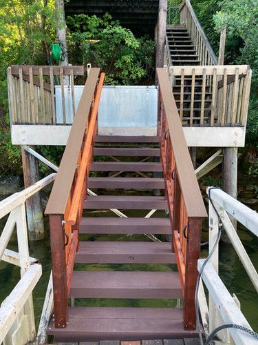 A wooden bridge over a body of water with stairs leading up to it.