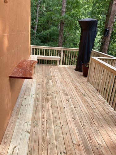 A wooden deck with a bench and a grill on it.