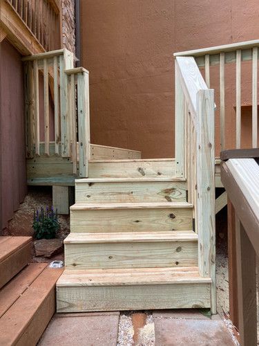 A wooden deck with stairs and a railing.