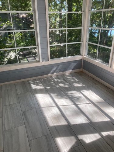 A room with a lot of windows and a tiled floor.